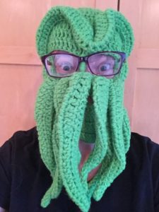 Picture of someone in a knitted Cthulhu mask.
