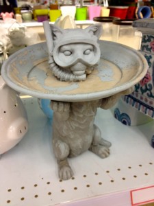 Image of a birdbath in the shape of a cat with a scuba mask.